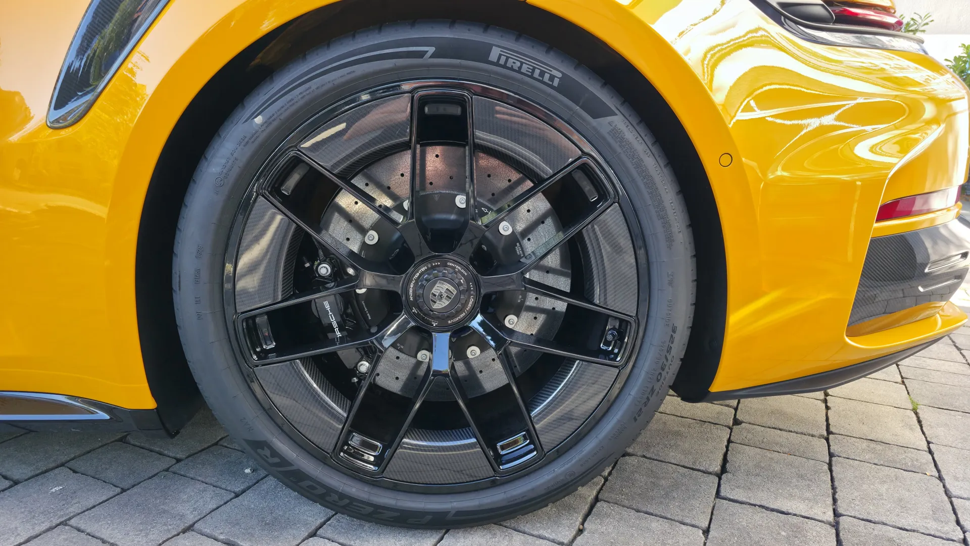 Gereinigte schwarze Porsche-Felge mit Keramikbremse nach der Felgenaufbereitung bei GT Service München